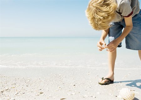 summer beach break - Child picking up seashells on beach Stock Photo - Premium Royalty-Free, Code: 632-01154710