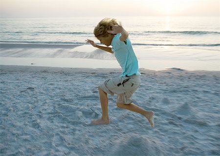 profile of boy jumping - Boy jumping on beach, side view Stock Photo - Premium Royalty-Free, Code: 632-01154733