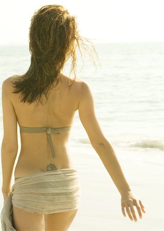 Woman walking on beach wearing sarong over bikini, rear view Stock Photo - Premium Royalty-Free, Code: 632-01154855