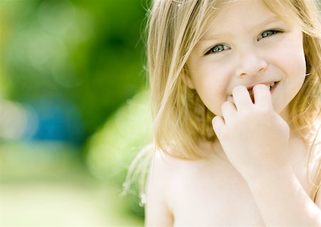 Little girl with fingers in front of mouth, portrait Stock Photo - Premium Royalty-Free, Code: 632-01154961