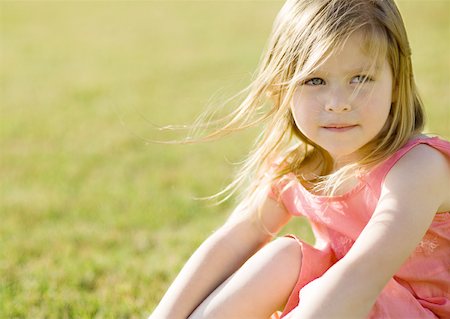 Little girl sitting on grass, hair blowing in wind Foto de stock - Sin royalties Premium, Código: 632-01154963