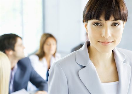 simsearch:632-01157433,k - Businesswoman smiling at camera, meeting in background, portrait Stock Photo - Premium Royalty-Free, Code: 632-01155341