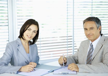 simsearch:632-01155457,k - Business executives signing documents, smiling at camera Stock Photo - Premium Royalty-Free, Code: 632-01155355