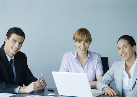 simsearch:632-01155400,k - Business colleagues gathered around laptop, smiling Stock Photo - Premium Royalty-Free, Code: 632-01155397