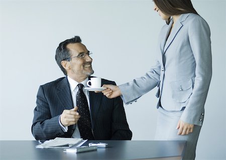 simsearch:632-01155400,k - Woman handing mature businessman cup of coffee Stock Photo - Premium Royalty-Free, Code: 632-01155406