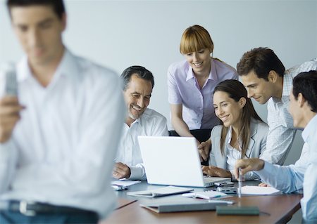 simsearch:632-01155400,k - Business colleagues gathered around laptop, smiling Stock Photo - Premium Royalty-Free, Code: 632-01155419