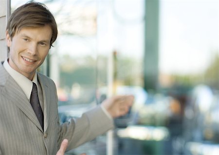 smile business blur - Young businessman smiling at camera and gesturing Stock Photo - Premium Royalty-Free, Code: 632-01155489