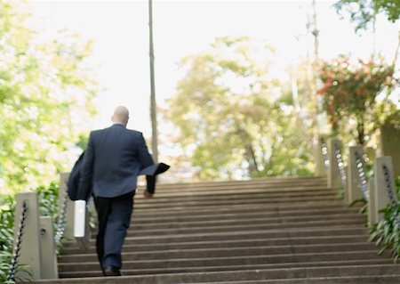Businessman walking up stairs, rear view Foto de stock - Sin royalties Premium, Código: 632-01155511