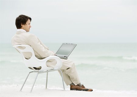Businessman sitting in chair on beach, with laptop Stock Photo - Premium Royalty-Free, Code: 632-01155536