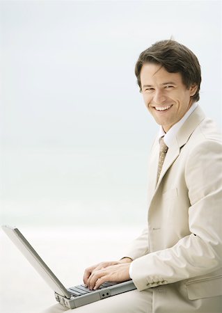 Businessman using laptop, smiling at camera Stock Photo - Premium Royalty-Free, Code: 632-01155550