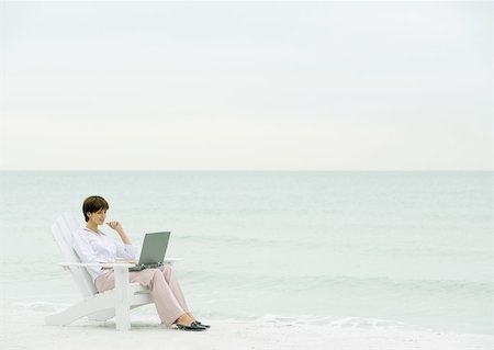 Woman using laptop on beach Stock Photo - Premium Royalty-Free, Code: 632-01155552