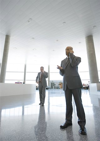 simsearch:695-03388701,k - Businessmen using cell phones in airport concourse Stock Photo - Premium Royalty-Free, Code: 632-01155609