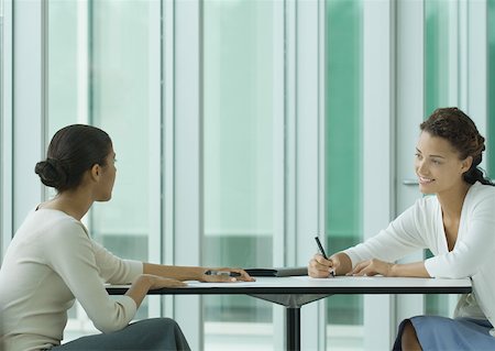simsearch:632-01155400,k - Two women sitting across from each other at table, working Stock Photo - Premium Royalty-Free, Code: 632-01155846