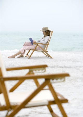 Woman on beach sitting in beach chair Stock Photo - Premium Royalty-Free, Code: 632-01156047