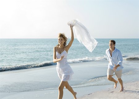 summer beach break - Couple on beach, man chasing woman Stock Photo - Premium Royalty-Free, Code: 632-01156261