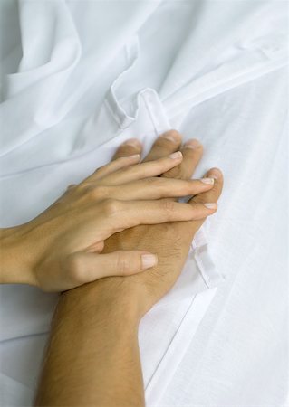 simsearch:695-03385360,k - Woman's hand on top of man's, on sheets Stock Photo - Premium Royalty-Free, Code: 632-01156285
