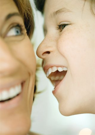 Boy whispering to woman, close-up of faces Stock Photo - Premium Royalty-Free, Code: 632-01156338