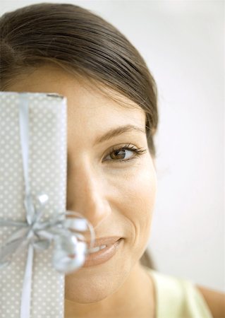 simsearch:632-01156362,k - Woman holding gift in front of face Stock Photo - Premium Royalty-Free, Code: 632-01156348