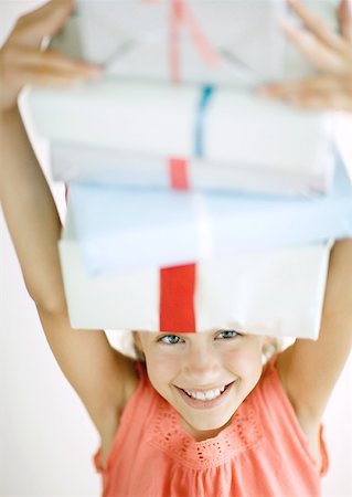 Girl holding stack of presents on head Stock Photo - Premium Royalty-Free, Code: 632-01156356