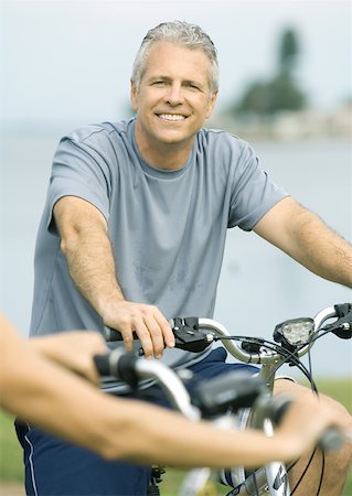 Mature man on bike, smiling Stock Photo - Premium Royalty-Free, Code: 632-01156467