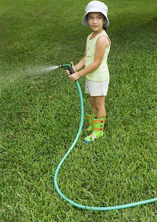 Little girl standing with garden hose Stock Photo - Premium Royalty-Free, Code: 632-01156553
