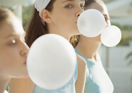 Preteen girls blowing bubbles with chewing gum Stock Photo - Premium Royalty-Free, Code: 632-01156692