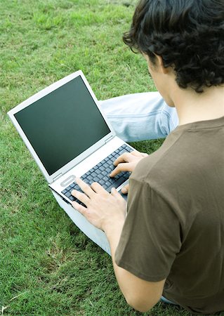 Young man sitting on grass, using laptop computer Stock Photo - Premium Royalty-Free, Code: 632-01156814