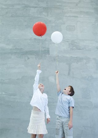 elio - Two children holding helium balloons Fotografie stock - Premium Royalty-Free, Codice: 632-01156899