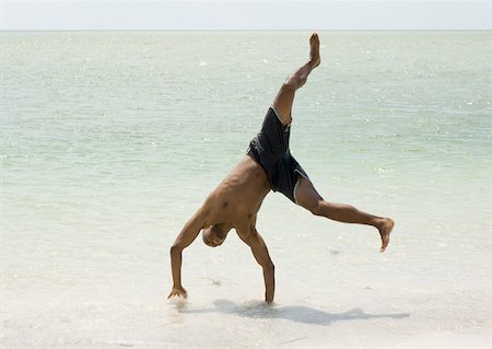 simsearch:632-02745223,k - Man doing cartwheel in surf Stock Photo - Premium Royalty-Free, Code: 632-01157099