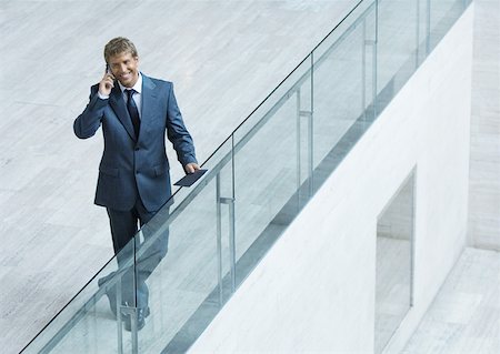 simsearch:632-01155443,k - Businessman leaning on railing, using cell phone, high angle view Fotografie stock - Premium Royalty-Free, Codice: 632-01157390