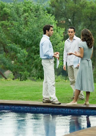 Casually dressed young executives working near edge of pool Stock Photo - Premium Royalty-Free, Code: 632-01157527