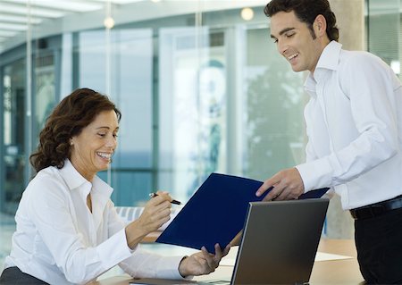 simsearch:632-01157586,k - Male office worker showing file to businesswoman Stock Photo - Premium Royalty-Free, Code: 632-01157600