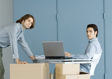 simsearch:632-05604394,k - Businessmen working at table top supported by cardboard boxes Stock Photo - Premium Royalty-Free, Code: 632-01157706