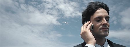 Man using telephone, airplane in sky Stock Photo - Premium Royalty-Free, Code: 632-01158933