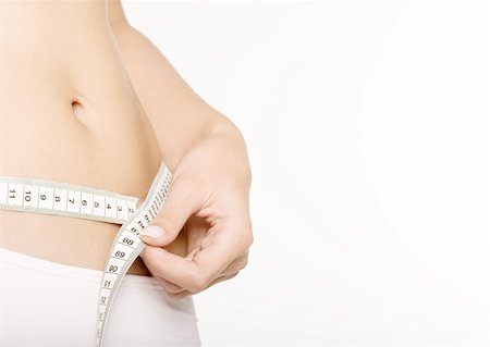 Woman measuring waist Stock Photo - Premium Royalty-Free, Code: 632-01159114