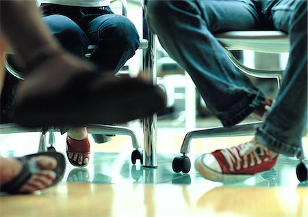 feet with sneakers - Legs and feet, view under table Stock Photo - Premium Royalty-Free, Code: 632-01150013