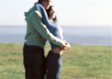 Young couple embracing, standing in grass near waters edge Foto de stock - Sin royalties Premium, Código: 632-01150048