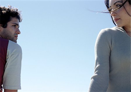 simsearch:632-01150072,k - Young man and young woman looking at each other with sky in background Stock Photo - Premium Royalty-Free, Code: 632-01150043