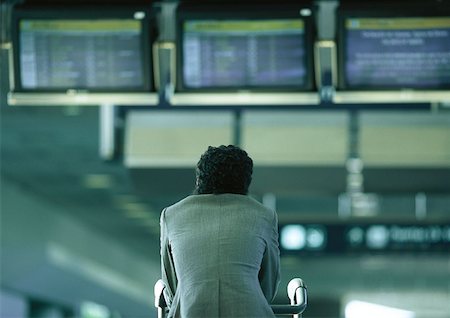 Businessman sitting under airport departure and arrival monitors, rear view Foto de stock - Sin royalties Premium, Código: 632-01150098