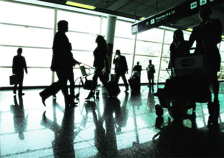 simsearch:695-03388701,k - Silhouettes of business people walking in airport terminal, backlit Stock Photo - Premium Royalty-Free, Code: 632-01150093