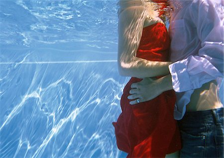 Fully clothed couple embracing in pool, underwater view Stock Photo - Premium Royalty-Free, Code: 632-01150280