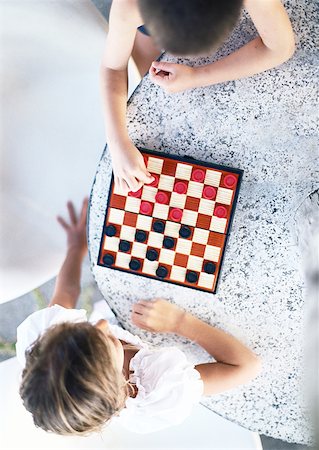 simsearch:695-03385371,k - Two children playing checkers, view from directly above Foto de stock - Royalty Free Premium, Número: 632-01150363