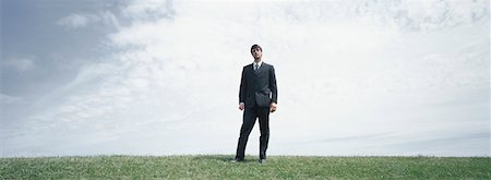 simsearch:632-03403439,k - Man in suit standing on grass looking at camera Fotografie stock - Premium Royalty-Free, Codice: 632-01151395