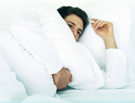 eiderdown duvet white - Man lying in bed on side holding pillow Stock Photo - Premium Royalty-Free, Code: 632-01151447