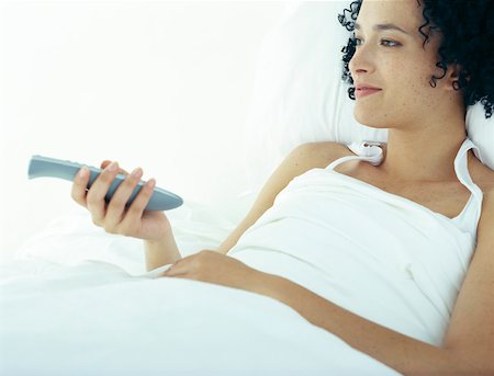 simsearch:632-02744819,k - Woman in bed under covers pointing remote control Foto de stock - Sin royalties Premium, Código: 632-01151457