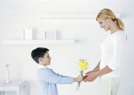 Boy holding out flowers to mother Stock Photo - Premium Royalty-Free, Code: 632-01151570