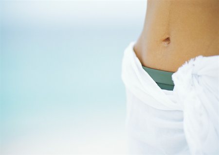 Woman wearing bikini and sarong, close-up of abdomen Stock Photo - Premium Royalty-Free, Code: 632-01152152