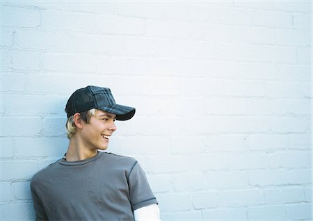 Teenage boy leaning against brick wall, portrait Stock Photo - Premium Royalty-Free, Code: 632-01152297
