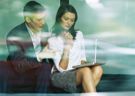 simsearch:695-03380508,k - Businessman and businesswoman sitting together, looking at laptop Stock Photo - Premium Royalty-Free, Code: 632-01152612