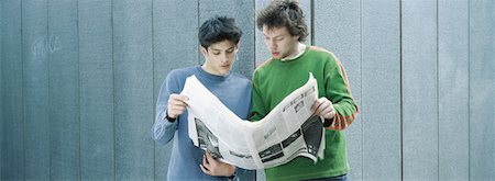 Two young men sharing newspaper Stock Photo - Premium Royalty-Free, Code: 632-01152719